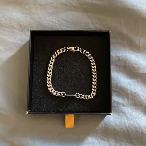 Silverfärgat armband från More Than 90 - Snyggt silverfärgat armband från More Than 90 med en klassisk kedjedesign och en fotbollsplan på. Perfekt för att ge en stilren touch till din outfit. Levereras i en elegant svart ask med gulddetaljer. Nypris: 450 kr