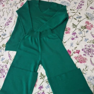 Grön stickad tröja med v-ringning och byxor  - Säljer en grön stickad tröja med v-ringning och långa ärmar. Byxor finns med, helt oanvänd köparen står för frakten ❤️