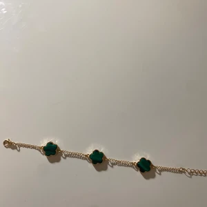 Guldhalsband och armband med gröna klöver - Elegant set med halsband och armband i guld med gröna klöverformade detaljer. Perfekt för att lägga till en färgklick till din outfit. Kedjan är fin och smidig, vilket ger en lyxig känsla. Säljer de 50kr var för sig annars kan man få båda för 80kr. Priset går att diskutera💞 
