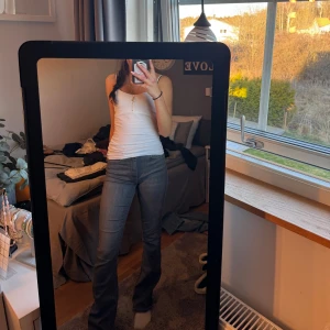 Grå bootcut jeans - Snygga grå bootcut jeans med en klassisk look. De har en hög midja och en bekväm passform som framhäver figuren. Perfekta för en stilren vardagslook.