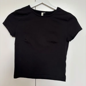 Svart kortärmad topp från Nelly - Säljer en svart crop top från Nelly i storlek XS. Säljer då en inte används.                               Längd: 43cm 