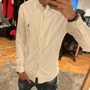Ralph Lauren skjorta  - Säljer en skit fet vit Raffe skjorta med nypris på 1600. Den sitter skit bra på mig som är 180 och skulle rekommendera att vara mellan 170-180 cm lång. Finns inga hål eller defekter.