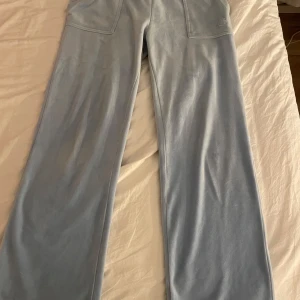 Ljusblå mjukisbyxor från Juicy Couture - Säljer ett par ljusblå mjukisbyxor från Juicy Couture. Lite små fläckar längst ner men annars fina💞