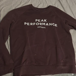 Brun tröja från Peak Performance - Säljer en brun tröja från Peak Performance med texten 'Peak Performance Original' på framsidan. Tröjan har långa ärmar och en rund halsringning. Perfekt för en avslappnad stil.