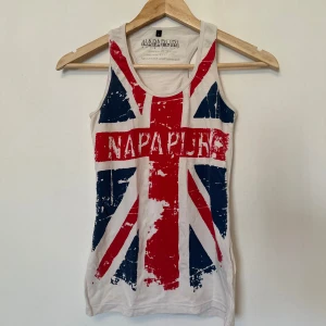 Vit linnetopp från Napapijri - Säljer en vit linnetopp från Napapijri med ett stort tryck av den brittiska flaggan i rött och blått.