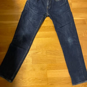 Mörkblå jeansbyxor - Snygga mörkblå jeansbyxor med klassisk femficksdesign. De har en rak passform och är perfekta för en avslappnad stil. Byxorna har en midwaist och är tillverkade i slitstarkt denim.