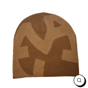 Brun Eva mössa - Snygg brun mössa med ett unikt mönster i olika nyanser av brunt. Perfekt för att hålla värmen under kyliga dagar. Den är stilren och passar till många olika outfits.