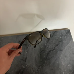  Ray-Ban wayfarerers 4181 - Snygga solglasögon från Ray-Ban med en klassisk design. Bågarna har en sköldpaddsmönstrad finish och glasen är tonade i en mörk nyans. Perfekta för soliga dagar och ger en stilren look. De är model RB 4181. 710/51.