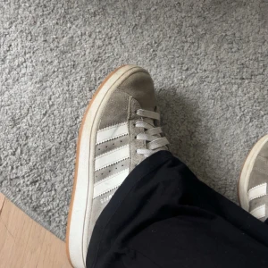 Adidas Campus grå - Säljer ett par Adidas Campus sneakers i grå mocka med vita ränder och vit sula. Slitage i hälen säljer därför billigt💗