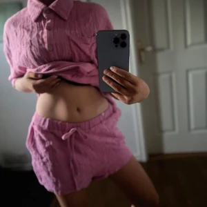 Rosa oversized set shorts  skjorta med knappar - Säljer en chill rosa shorts och  skjorta med oversized passform och stora knappar framtill. Skjortan har krage, bröstfickor och är gjord i ett mjukt, krinklat bomullstyg. Perfekt för dig som gillar avslappnad stil och vill ha något som sticker ut lite extra.