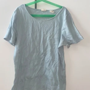 Ljusblå ribbad t-shirt från Levi's - Snygg ljusblå t-shirt från Levi's i storlek L. T-shirten har korta ärmar, rund hals och är tillverkad i ribbad bomull som ger en skön och avslappnad vibe. Perfekt för dig som gillar enkel och stilren design med en touch av klassisk Levi's. Såklart får du som köper den strykt