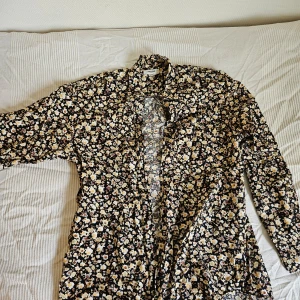 Blommig långärmad skjorta - Svart blommig skjorta med ljusgult blommönster (färgen är mer som på närbilden). 