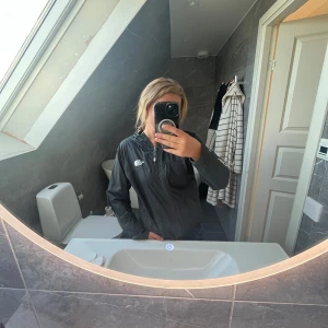 Svart vindjacka från The North Face - Säljer en svart vindjacka från The North Face med huva och dragkedja , passar väldigt bra till tränings jacka  .