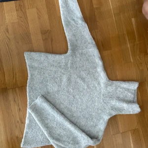 Ljusgrå polotröja från Dr Denim - Mysig ljusgrå polotröja från Dr Denim i storlek XS. Tröjan är stickad med en hög polokrage och har långa ärmar.