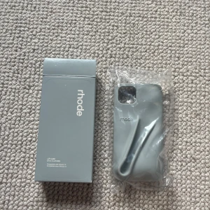 Rhode skal iPhone13💕💕 - Nypris 360, säljer för 300!!! Har aldrig använt och har inte ens öppnat de! Jätte fint grått skal som man kan ha läppglans osv för.❤️förhandlar pris!