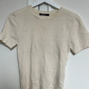 Beige ribbad topp  - Beige ribbad topp från Gina Tricot med rund halsringning och korta ärmar.