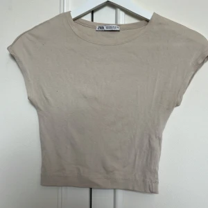 Beige croppad topp från Zara - Superskön beige croppad T-shirt!