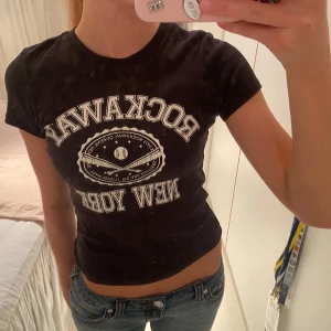Rockaway New York t-shirt - Svart/mörkgrå t-shirt med vit text 'ROCKAWAY NEW YORK'. Ger snygga Y2K vibbar😍Passar superbra till jeans! Använd ett fåtal gånger🫶🏼 Storlek S. Fråga gärna om du undrar något :)   