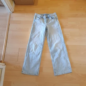 Ljusblå raka jeans i straight fit från H&M - Säljer ett par ljusblå jeans med rak passform och klassisk femficksdesign. Jeansen har normal midja och är tillverkade i bomull. Perfekta för en avslappnad och stilren look.