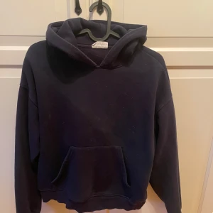 Mörkblå hoodie från Gina Tricot XXS - En basic mörkblå hoodie från Gina Tricot, basically basics-kollektionen. Tröjan har huva, magficka och långa ärmar. Perfekt för chill dagar och enkel att matcha med jeans eller mjukisbyxor.