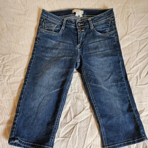 Lowrise skinny long shorts - Shorts i lite över knähöjd, relativt lowrise, med assymetriska bältesloopar och knappar på bakfickorna, y2k vibes. På insidan av bakfickeknapparna har jag limmat på tyg pga min nickelallergi lol, det är dock inget som syns på utsidan eller påverkar något. 