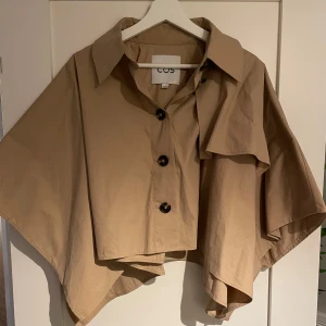 COS poncho  - COS poncho trench coat, så fin! köptes ny och använd kanske 5 gånger, fint skick. 