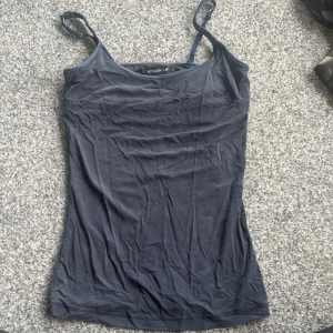 Mörkblå linnetopp från STOCKH LM XS - En enkel och stilren mörkblå linnetopp från STOCKH LM i storlek XS. Toppen har smala axelband och är figurnära med rundad halsringning. Perfekt att matcha med jeans eller kjol för en clean look.