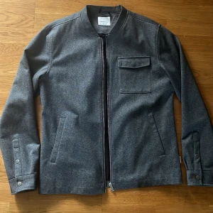 Tunn jacka Lindbergh White - Snygg grå jacka från Lindbergh White. Perfekt för dig som gillar stilren look. Aldrig använd! Nyskick men har ingen lapp kvar! Pris kan diskuteras!