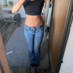 Blå bootcut jeans - Säljer ett par blå jeans med ovanlig blå färg. Jeansen har låg midja, fem fickor och snyggt slitna detaljer. Tillverkade i mjukt denimtyg som sitter skönt hela dagen. Denna modellen säljs inte längre