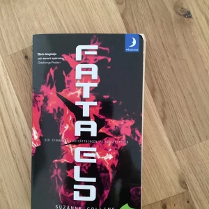 Hunger Games del 2=Fatta eld - Fatta eld är den spännande fortsättningen på Hungerspelen. Följ Katniss och Peeta när de tvingas tillbaka in i en brutal tävling där bara en överlever och allt direktsänds. Perfekt för dig som gillar action, starka karaktärer och dystopiska berättelser.