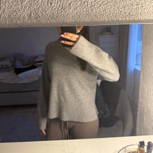 Grå stickad tröja - Mysig grå stickad tröja med långa ärmar och ribbad nederkant. Perfekt för kyligare dagar och enkel att matcha med olika outfits.