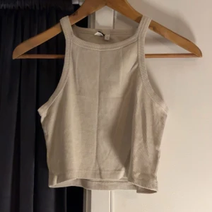 Beige ribbad linnetopp från NLY Trend - Säljer en snygg beige ribbad linnetopp från NLY Trend. Toppen är ärmlös och croppad, perfekt för varma dagar. Den har en stilren design som passar till många olika outfits.💕
