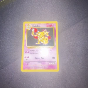 Kadabra Pokémon kort (1995-2000) - Säljer ett Pokémonkort med Kadabra med ett litet väck i mitten. Kortet har en gul ram och visar Kadabra med 60 HP. Det har attacker som Recover och Super Psy. Perfekt för samlare eller Pokémon-fans!