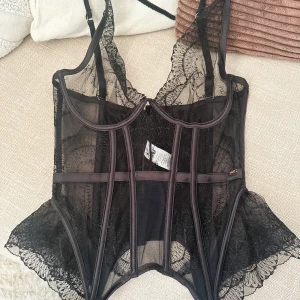 Spetskorsett från Hunkemöller - Akira bustier från Hunkemöller i storlek 32DD (70DD). Den har volanger nertill i sidorna så den blir lite utställd, och glittertråd i spetsen. Aldrig använd, nypris 749 kr.  Jag kan skicka fler bilder på hur den ser ut på modellen vid förfrågan.
