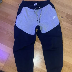 Nike tech fleece byxor svarta och grå   - Säljer ett par Nike tech fleece mjukisbyxor i svart och grå. Knappt använda/ Väldigt bra skick. Storlek M. Pris går att diskuteras✅