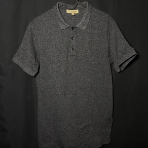 Burberry piké | Grå | Slim Fit | Stl M - Läs nedan för mer info!😊  Säljer en stilren grå pikétröja från Burberry. Tröjan har korta ärmar och en klassisk krage med knappar framtill. Perfekt för en avslappnad men ändå elegant look. Tillverkad i mjukt material för extra komfort.  Produktinformation:  ✅ Märke: Burberry  ✅ Storlek: M  ✅ Färg: Grå ✅ Material: Bomull ✅ Passform: Slim fit – perfekt att styla med jeans eller chinos. ✅ Skick: Mycket bra skick, knappt använd  Frakt och betalning: 📦 Snabb leverans – skickar inom 1-2 dagar📦