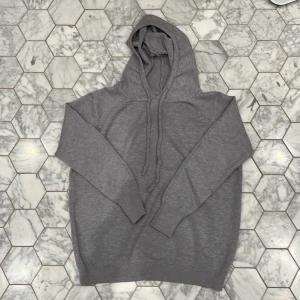 Grå merinoull hoodie - Säljer en stilren grå merinoull hoodie med långa ärmar och en snygg huva. Perfekt för en avslappnad look. Den har ribbade muddar vid ärmslut och nederkant. Unbranded 100% merinoull i storlek xxs men väldigt stretchig i materialet. Priset är inte hugget i sten!