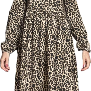 Leopardmönstrad klänning - Trendig leopardmönstrad klänning med långa ärmar och en bekväm passform. Perfekt för att sticka ut med stil. 🐆