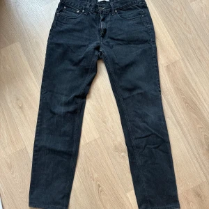 Svarta jeans från Acne - Snygga svarta jeans från Acne med klassisk femficksdesign och dragkedja. De har en rak passform och är perfekta för en stilren look. Passar till många olika tillfällen och outfits.