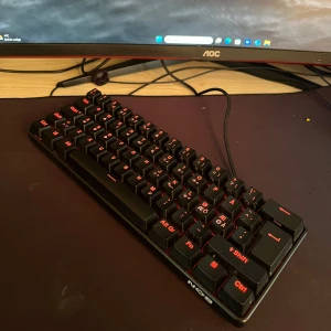 NOS C250 RGB Mekaniskt Tangentbord - Säljer ett NOS C250 RGB mekaniskt tangentbord med röda switchar. Tangentbordet har en kompakt design och justerbar RGB-belysning som kan anpassas efter din stil. Perfekt för gaming och skrivande med linjära tangenter för snabb respons. Ansluts via USB och är kompatibelt med PC.