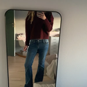 Blå bootcut jeans - Snygga blå bootcut jeans med klassisk femficksdesign och kontrastsömmar. Perfekta för en avslappnad stil. De har en knapp och dragkedja framtill.