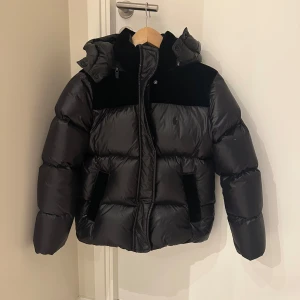 Svart dunjacka från Ralph Lauren - Säljer en fin svart dunjacka från Ralph Lauren. Den är sparsamt använd och har inga defekter! Säljer då den är något liten på mig. Den är i strl 12-14 yr alltså L i barnstorlek men sitter ungefär som en XXS eller XS. Bara att höra av sig vid frågor💞