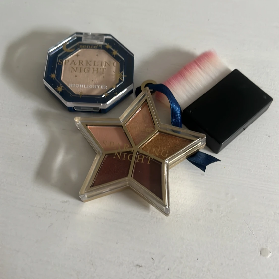 Sminkset med highlighter, ögonskugga och borste