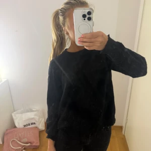 Svart stickad tröja från Zara - Mysig svart stickad tröja från Zara i storlek M. Tröjan har rund hals och långa ärmar med ribbade muddar. Perfekt för kyliga dagar och enkel att matcha med jeans eller kjol. Stilren och klassisk design som funkar till många olika looks.