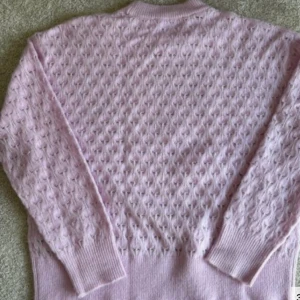 Ljuslila stickad tröja från Samsøe Samsøe - Superfin ljuslila stickad tröja från Samsøe Samsøe med ett snyggt hålmönster över hela tröjan. Rund hals och långa ärmar med ribbade muddar. Perfekt att styla med jeans eller kjol för en chill look.