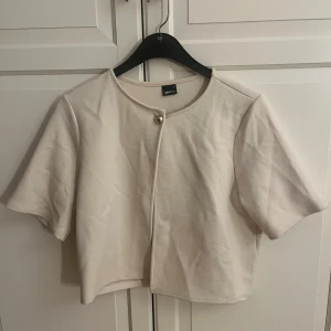 Beige kofta med guld knapp - Säljer en beige kofta med trekvartsärm med guld knapp från Gina Tricot i storlek L. Jag bär vanligtvis storlek S/M och anser att storlek L passade bättre i passform.