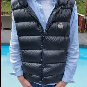 Svart dunväst från Moncler - Snygg svart dunväst från Moncler med quiltad design och dragkedja,västen är inte använd alls många gånger och är i perfekt skick.priset kan såklart diskuteras.skriv frågor vid funderingar!!❤️🍾🍾🙏🏼🙏🏼