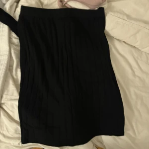 Svart kjol från SHEIN, storlek S - En svart, enkel och stilren kjol från SHEIN i storlek S. Kjolen är rak i modellen och har en kort längd, perfekt att matcha med olika toppar. Materialet känns mjukt och lätt, och den svarta färgen gör den lätt att styla.