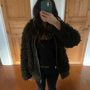 Mörkgrön teddyjacka från H&M - Säljer en fluffig och mysig mörkgrön teddyjacka från H&M i storlek 36. Jackan har dragkedja framtill, och ribbade muddar. Använt några gånger💕