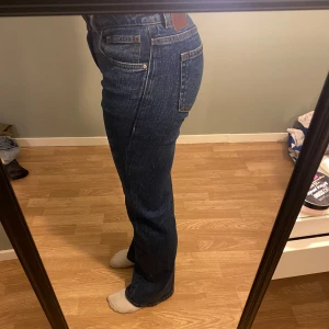 Bikbok blå bootcut jeans -  jeans i mörkblå denim. Jeansen har bootcut passform, låg midja och raka ben med lätt utsvängning nertill. Snygga kontrastsömmar och femficksmodell. Använda en gång då jag har liknande redan 